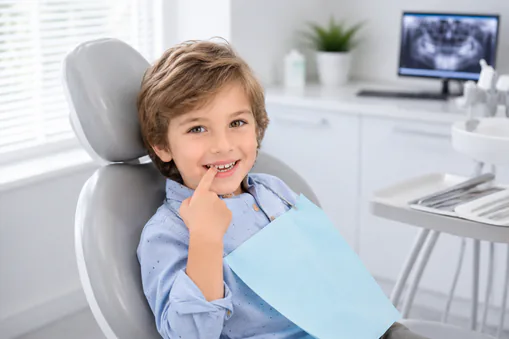 young boy at dental office pointing to tooth